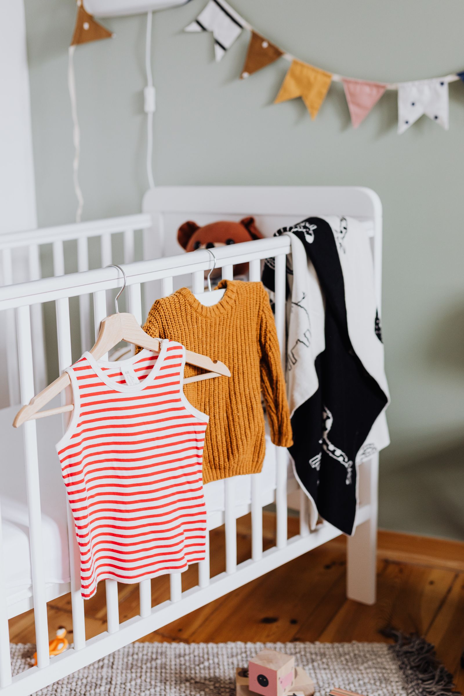 Vêtements de bébé disposés sur un lit dans une chambre d'enfant, idées de liste de naissance